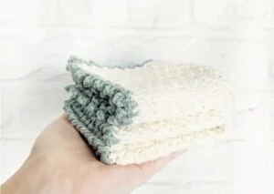 a hand holding washcloths