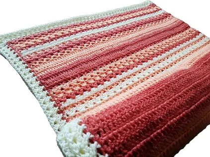 crocheted blanket in shades of orange