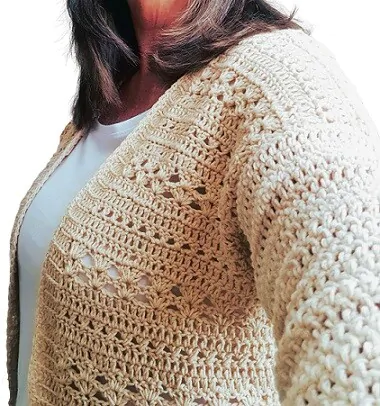 a side view of a woman in a white tee and oat coloured crochet cardigan