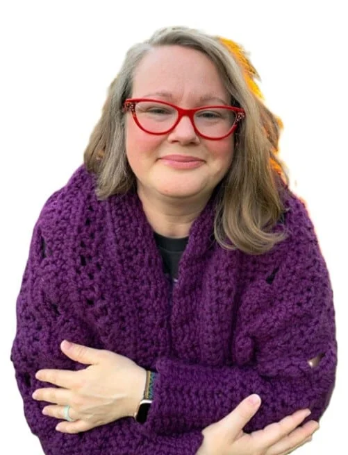 A cocoon cardigan is styled on a woman leaning forwards