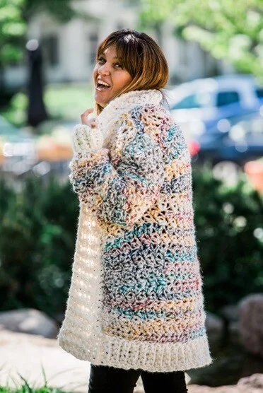 A woman is out walking wearing a long cozy cardigan