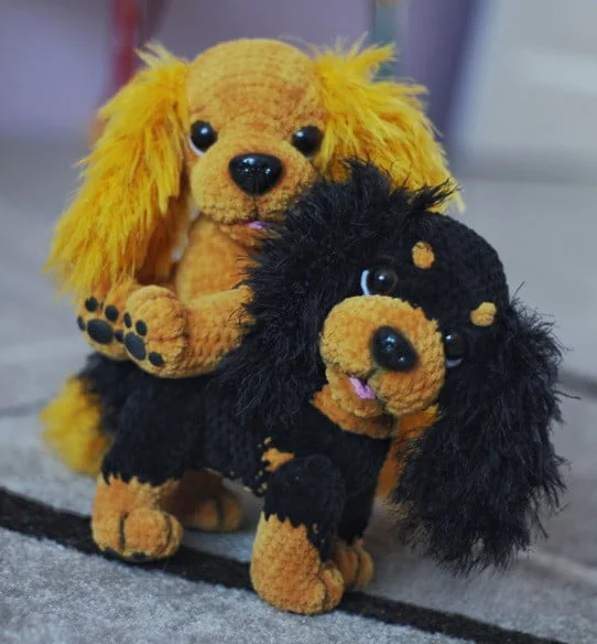 two crocheted Cavalier King Charles Spaniels are playing