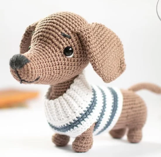A toy Dachshund/Weiner wearing a sweater