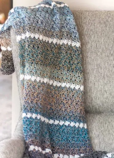 A blanket is draped over the corner of a sofa