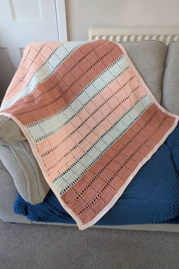 Marlowe crochet lap blanket draped over a sofa