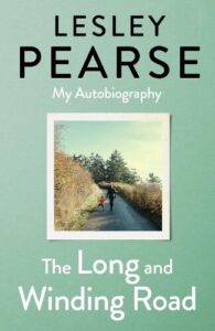 book cover for Lesley Pearse's autobiography The Long and Winding Road. A photo of an adult holding a child's and they are both walking along a lane