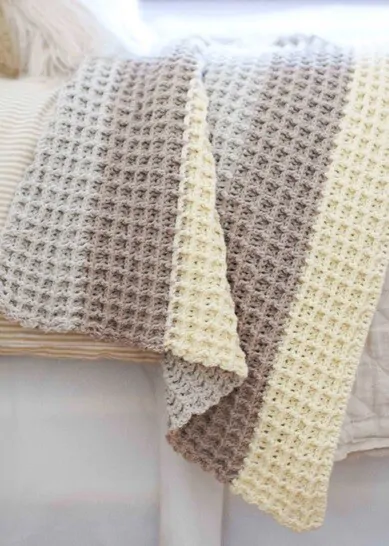 A blanket is draped over the back of a sofa