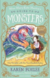 book cover for The Trouble with the Two-Headed Hydra by Karen Foxlee. Miss Mary-Kate is walking along the sand with a colourful two-headed hydra behind her in the waves