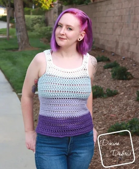 A woman is wearing a multi-coloured tank top styled with jeans