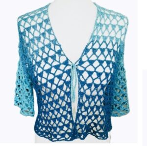 An open stitch crochet bolero in shades of turquoise is styled on a mannequin showing the front view