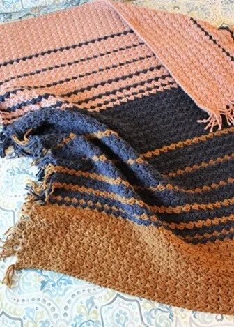 A blanket in different size stripes is laid flat