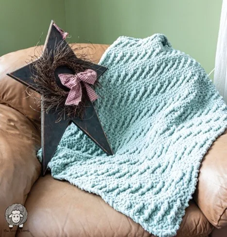 A throw is draped over the arm of a chair