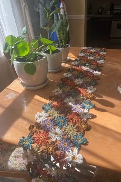 Crocheted flowers arranged into a rectangle create this vibrant table runner