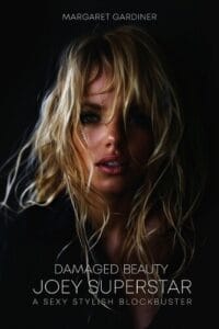 Book cover for "Damaged Beauty: Joey Superstar" by Margaret Gardiner. The cover features a close-up of a woman with tousled blonde hair partially covering her face, teary eyes, and a sultry expression, set against a dark background. Below the title, it reads: "A Sexy Stylish Blockbuster" in sleek, modern typography.
