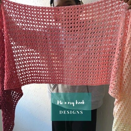 ectangular crochet shawl held up to show its open lace pattern and gradient color transition from deep red to soft peach. The airy texture and warm tones make it a lightweight, eye-catching accessory