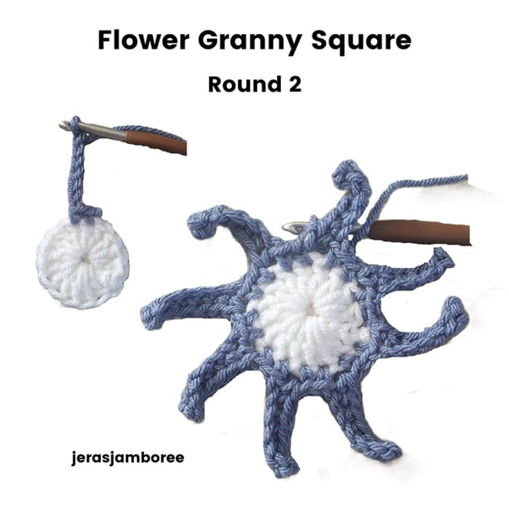 Flower Granny Square Round 2 showing blue yarn joined to the white centre. The image illustrates chain loops being formed around the centre circle to create the base for the eight flower petals.