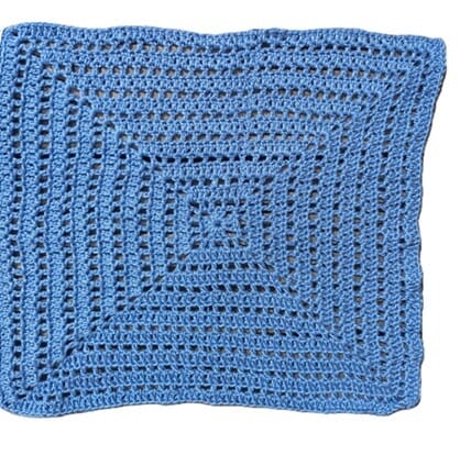 Close up of a granny square worked in a simple mesh stitch (double crochet, chain 1, skip 1 stitch)