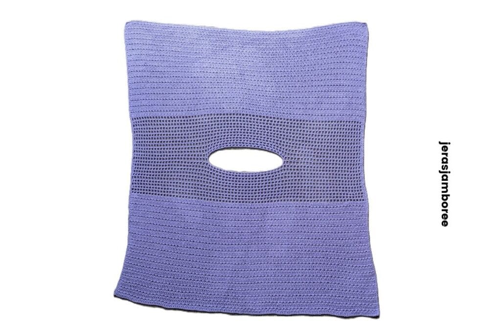 Flat lay of the lavender crochet poncho showing rectangle construction, mesh yoke section and neckline opening worked into the centre.