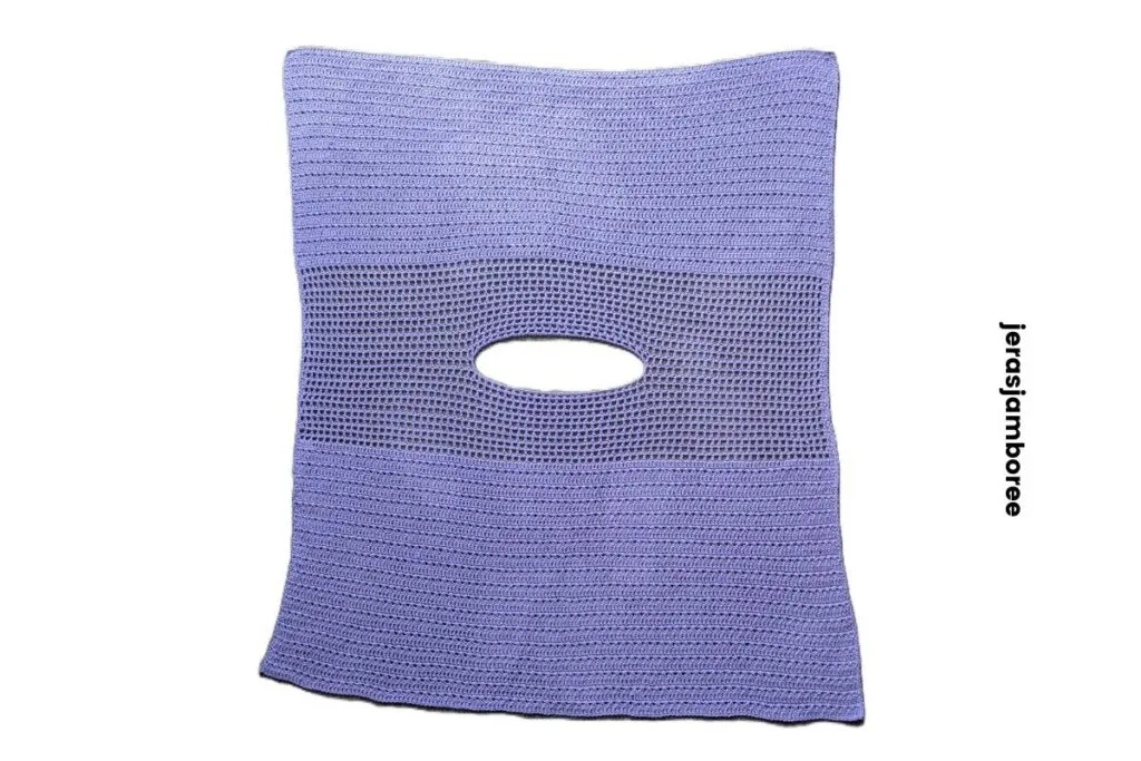 Flat lay of the lavender crochet poncho showing rectangle construction, mesh yoke section and neckline opening worked into the centre.