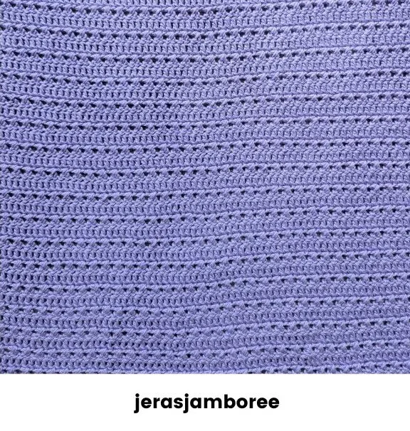 Close-up of crossed double crochet stitches in lavender DK yarn, showing textured rows from the body of the Lilienne poncho