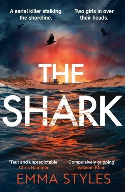 Book cover for The Shark by Emma Styles featuring a dramatic ocean sunset with waves in the foreground, seabirds flying overhead, and a lifeguard tower on the beach beneath a glowing sky.