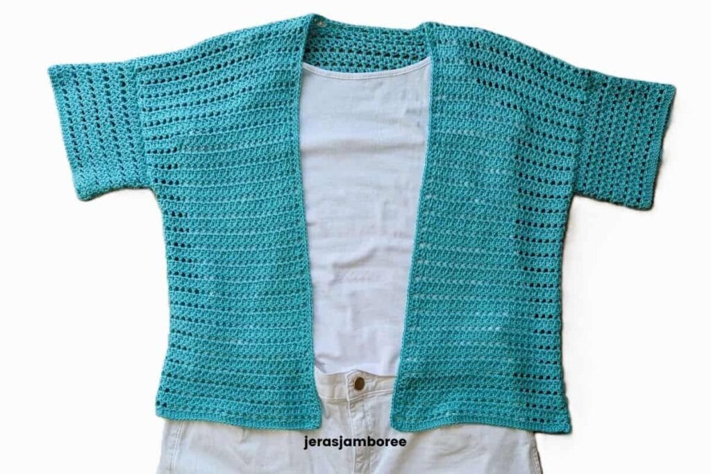 Sandrine short sleeve crochet cardigan shown flat over a white top, highlighting the open front design and mesh stitch pattern.
