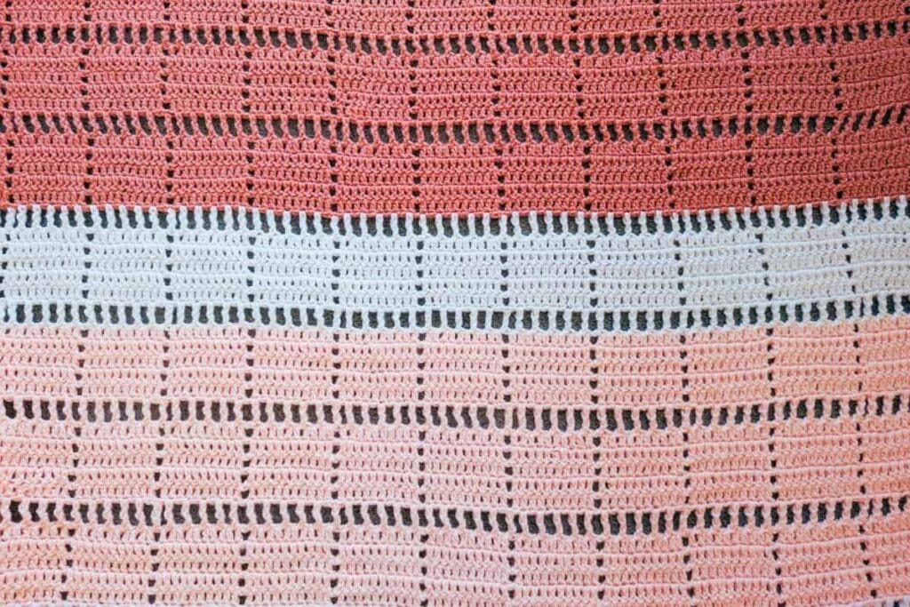 Close-up of the Marlowe lap blanket crochet pattern showing geometric double crochet filet blocks separated by open treble crochet mesh rows